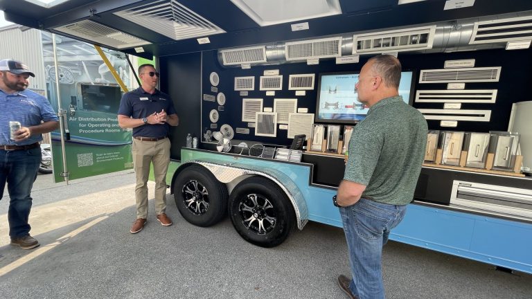 People surrounding trailer with product in it