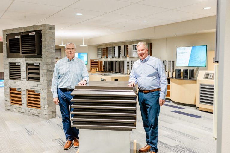 two men standing by manufacturing equipment