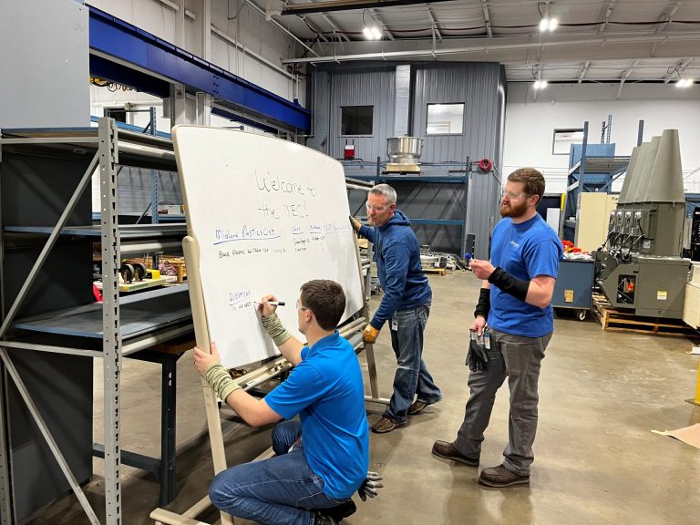 group of people writing on a white board